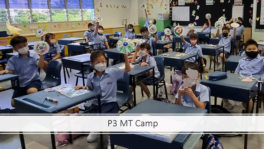 Students in uniforms and masks sit at desks, holding up decorated paper fans in a classroom.